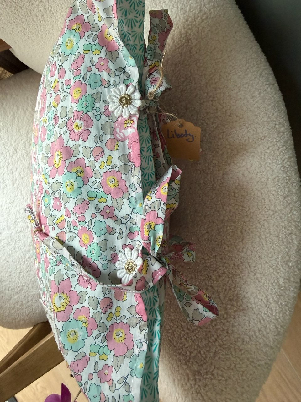 Fermeture par liens noués et fleurs de dentelle au dos du coussin en Liberty, cousu main