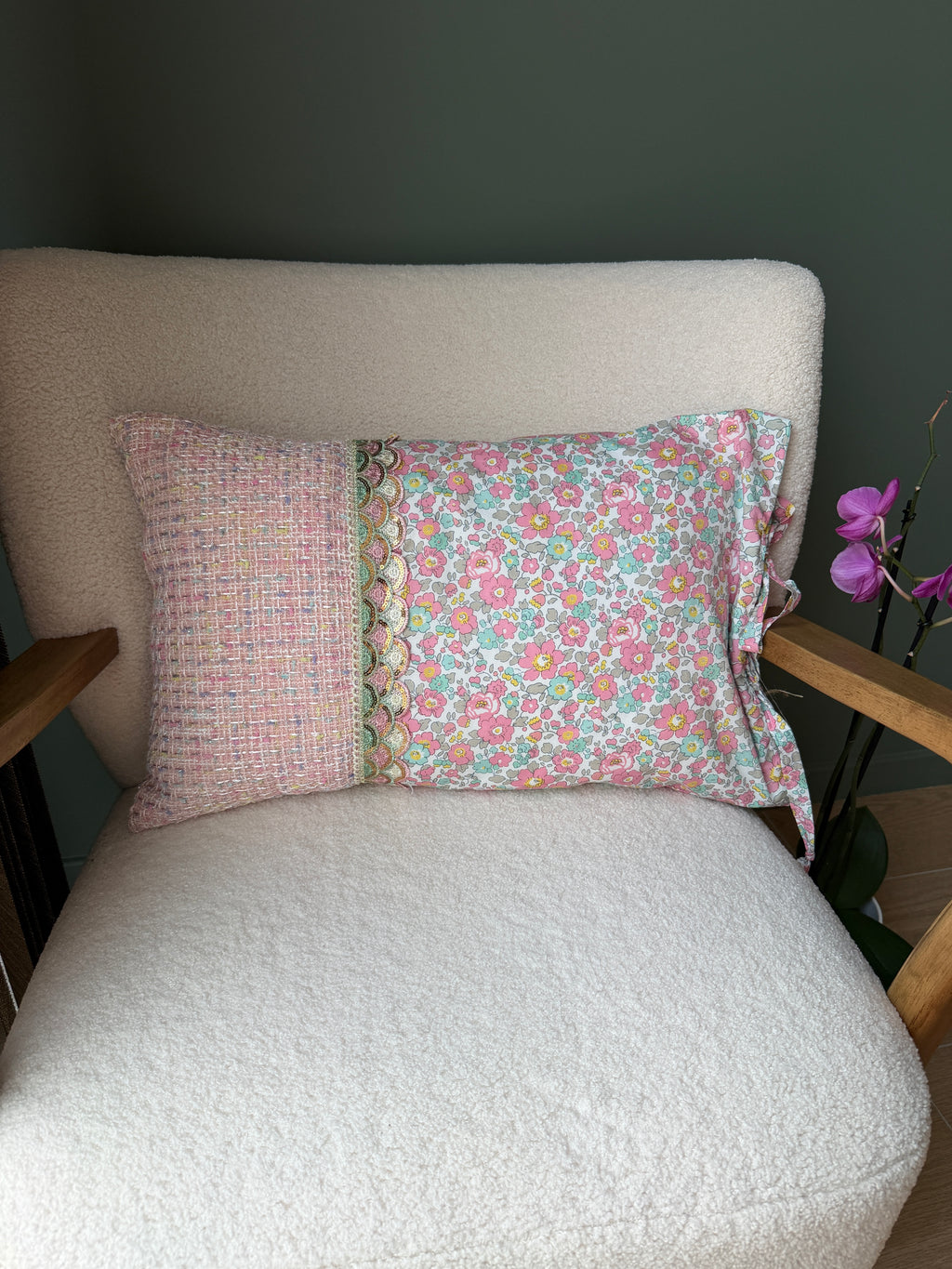 Verso du coussin en tweed rose et coton fleuri Liberty, séparés par un galon de dentelle festonné