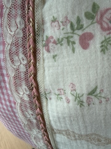 Gros plan coussin fait main Lyli Créarti, tissu floral vintage rose et vichy rose avec dentelle et galon torsadé doré
