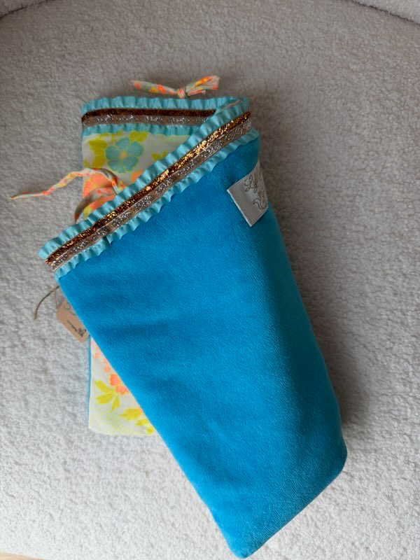 Pochette fait main Lyli Créarti, verso en tissu bleu turquoise uni, bordure plissée avec galon doré et étiquette artisanale