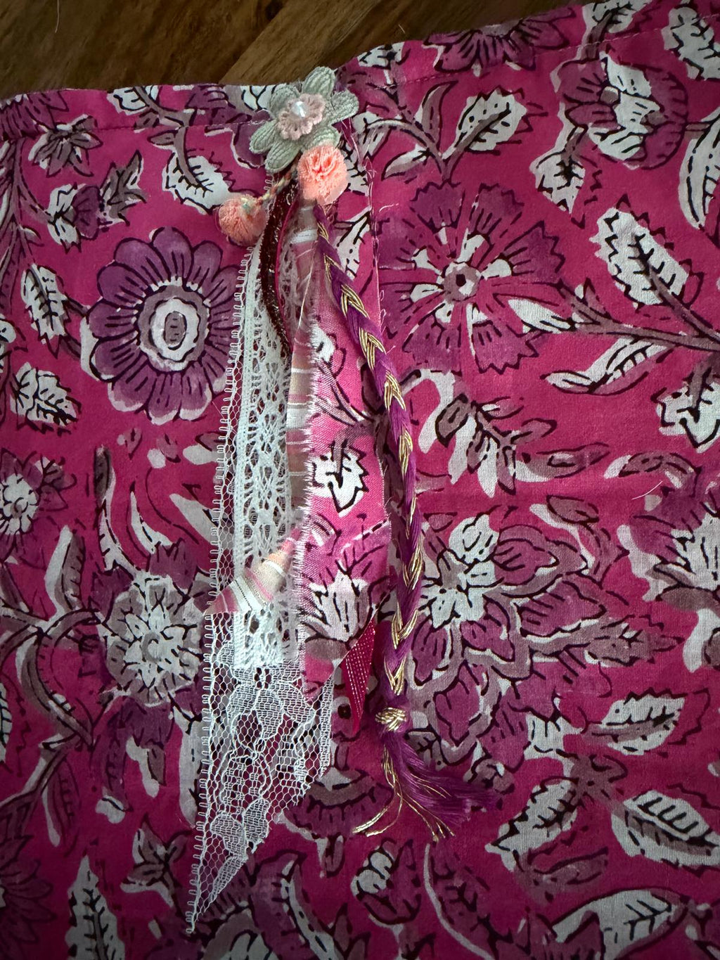 Détail broderie fleur et dentelle sur sac bourse en tissu floral rose