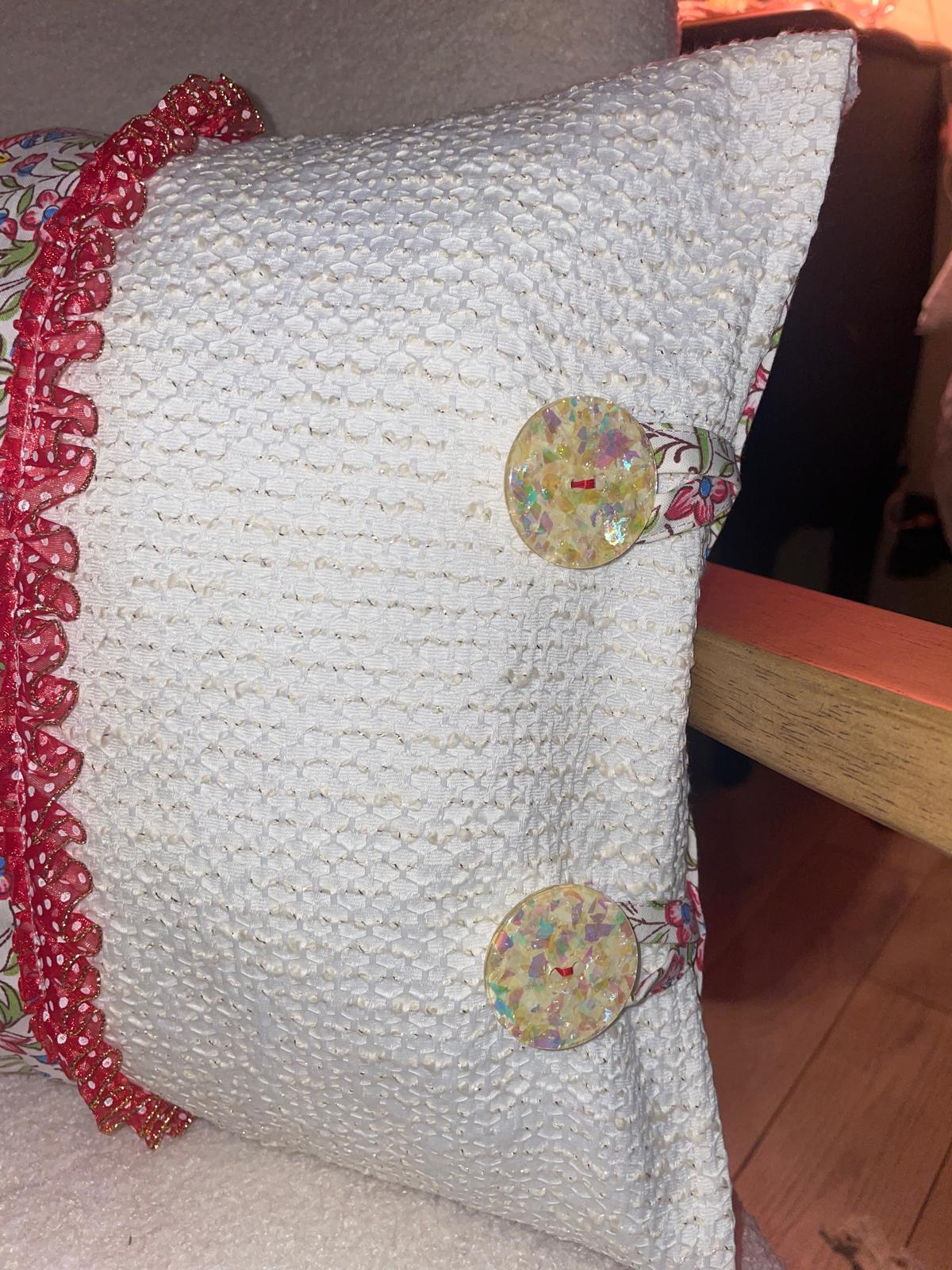Zoom coussin fait main Lyli Créarti, lin blanc texturé avec gros boutons fantaisie irisés et volant à pois rouge