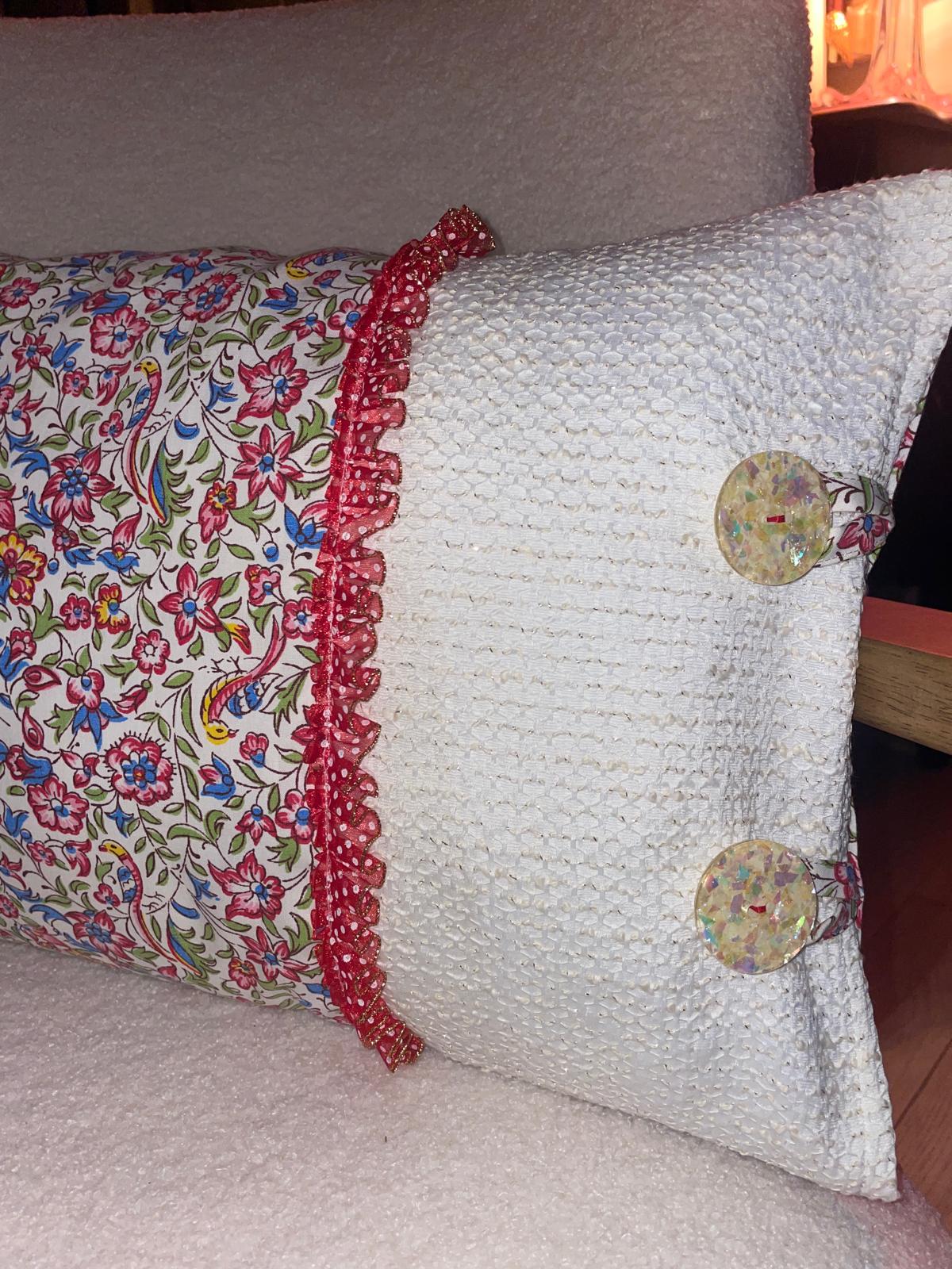 Coussin fait main Lyli Créarti vue de dessus, tissu imprimé fleuri oiseaux et lin blanc texturé, volant à pois rouge et gros boutons irisés