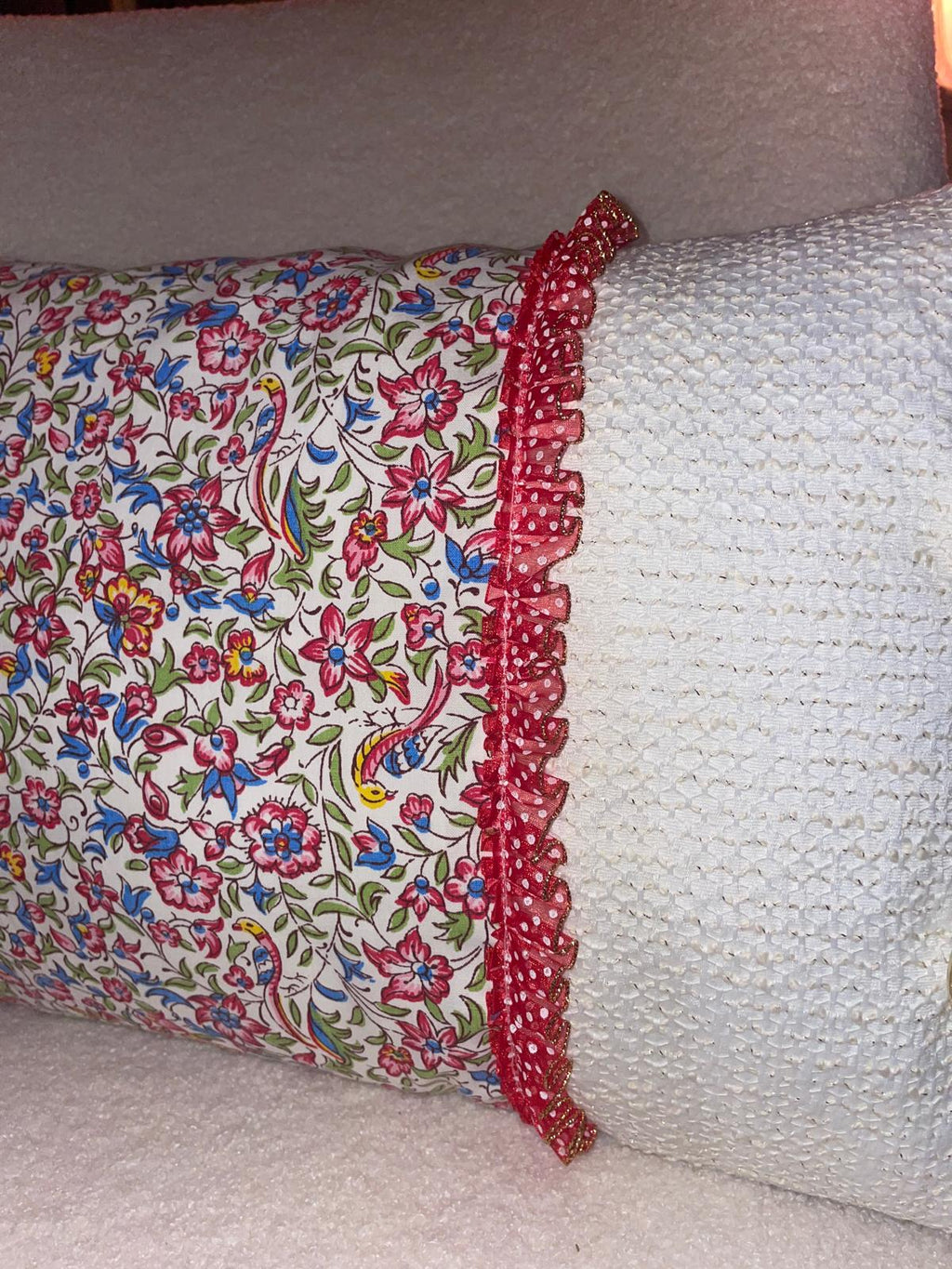 Zoom jonction coussin fait main Lyli Créarti, tissu imprimé fleuri oiseaux et lin blanc texturé, volant plissé à pois rouge