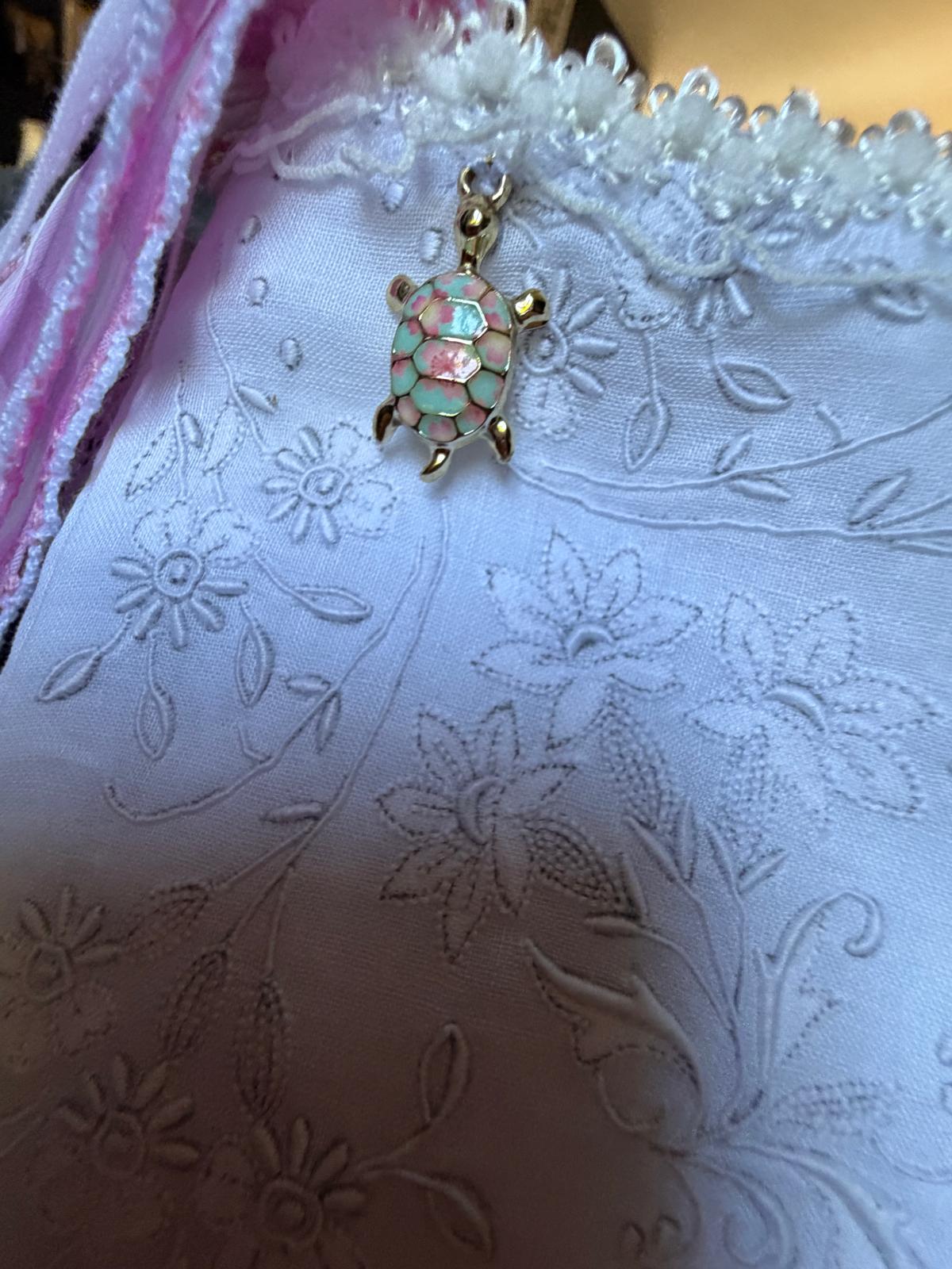 Sac à chaussons fait main Lyli Créarti, gros plan breloque tortue émaillée rose et vert sur lin blanc brodé