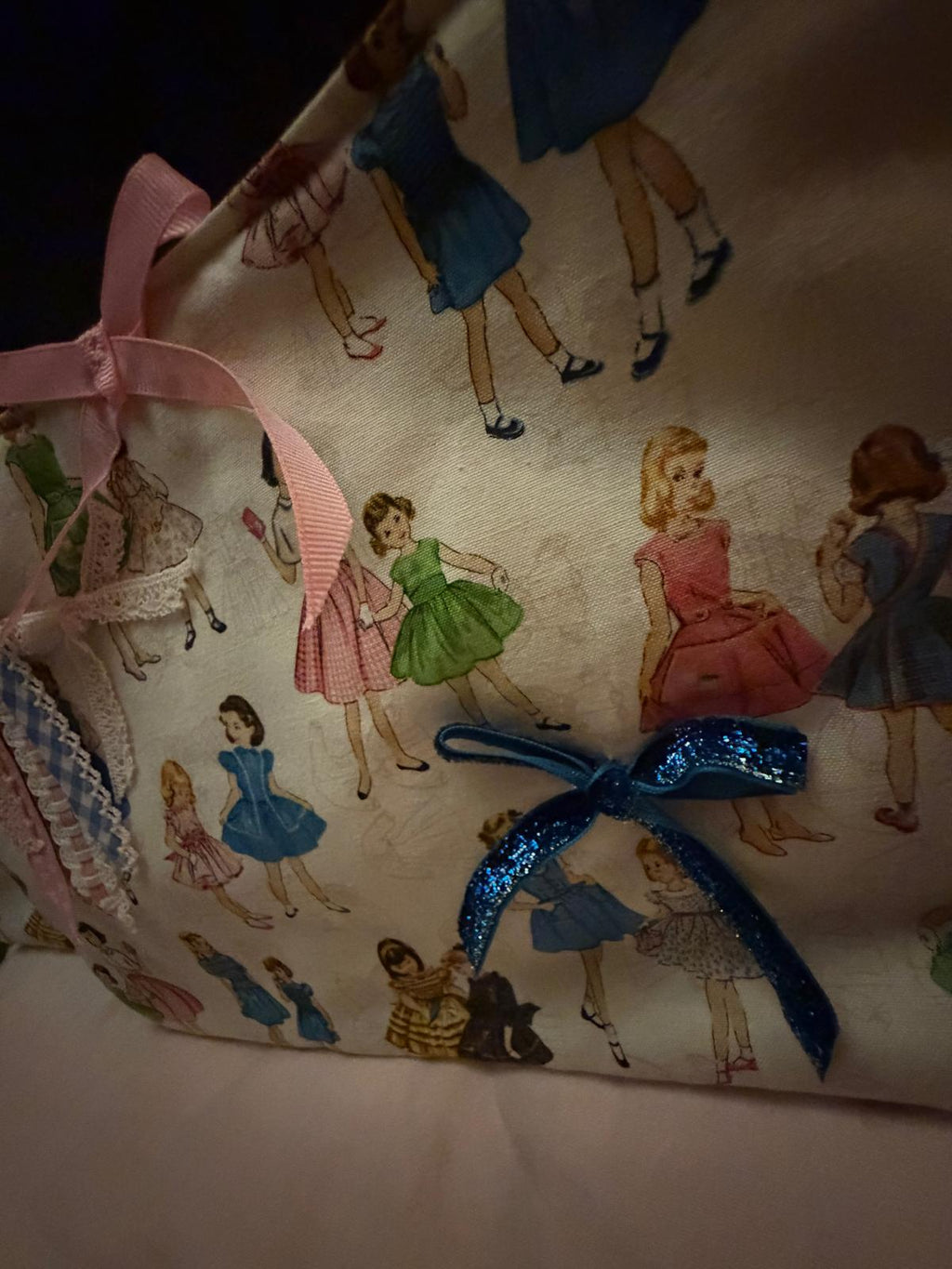Zoom pochette fait main Lyli Créarti, tissu imprimé fillettes vintage et noeud pailleté bleu
