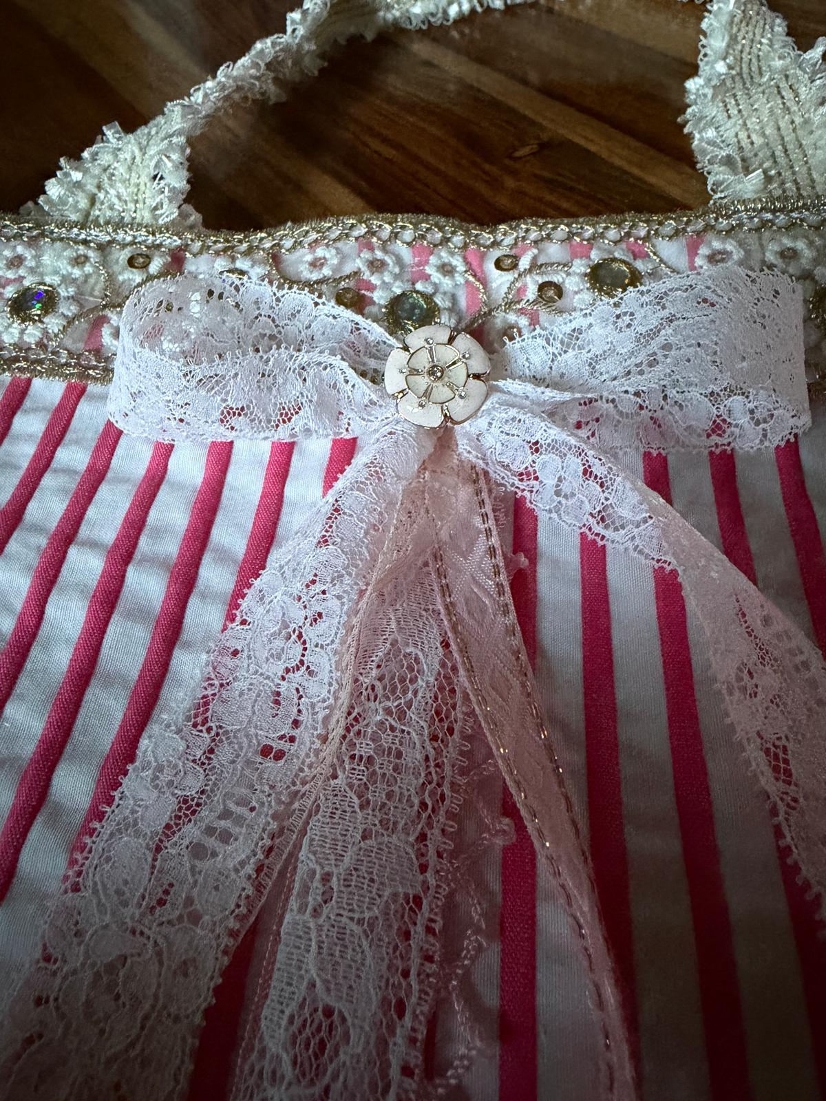 Zoom sac fait main Lyli Créarti, noeud en dentelle blanche et bouton fleur, tissu rayé rose et blanc, empiècement brodé de strass