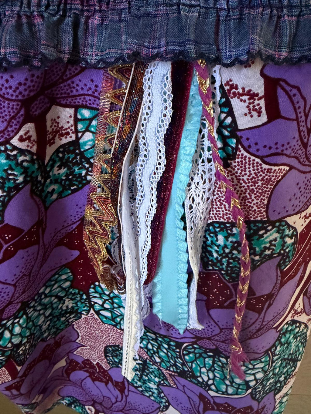 Zoom pompon rubans multicolores sac cabas fait main Lyli Créarti, tissu wax imprimé fleurs de lotus violet et turquoise