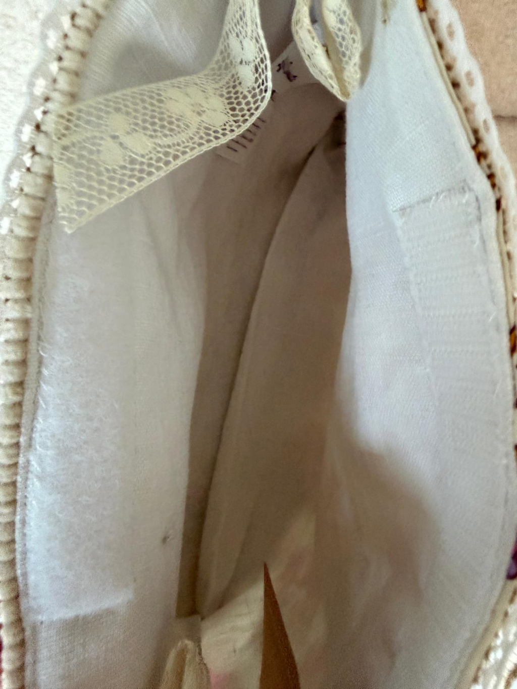 Intérieur bourse fait main Lyli Créarti, doublure en lin blanc avec noeud en dentelle et étiquette de marque