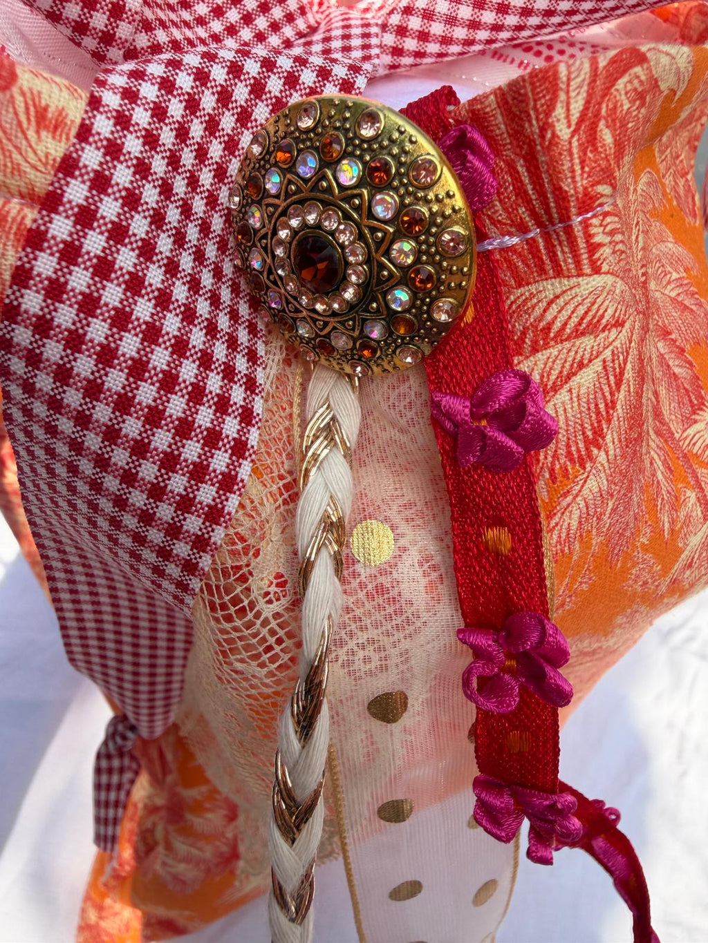 Zoom bouton bijou strassé sur bourse fait main, tulle doré et rubans fuchsia, anse à carreaux vichy rouge et blanc