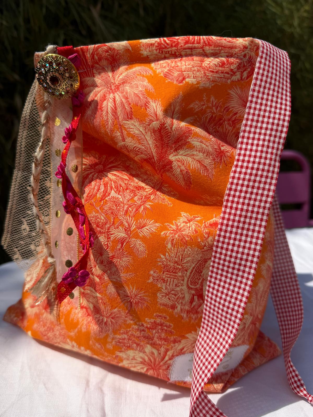 Bourse fait main en tissu imprimé toile de Jouy orange motif palmiers, anse à carreaux vichy rouge et blanc, bouton bijou et rubans en dentelle