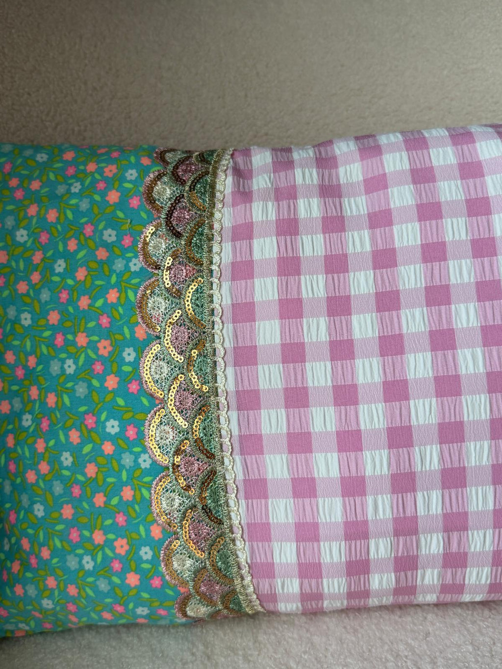 Zoom bordure coussin fait main, jonction tissu vichy rose et imprimé fleuri turquoise avec galon écaille brodé doré