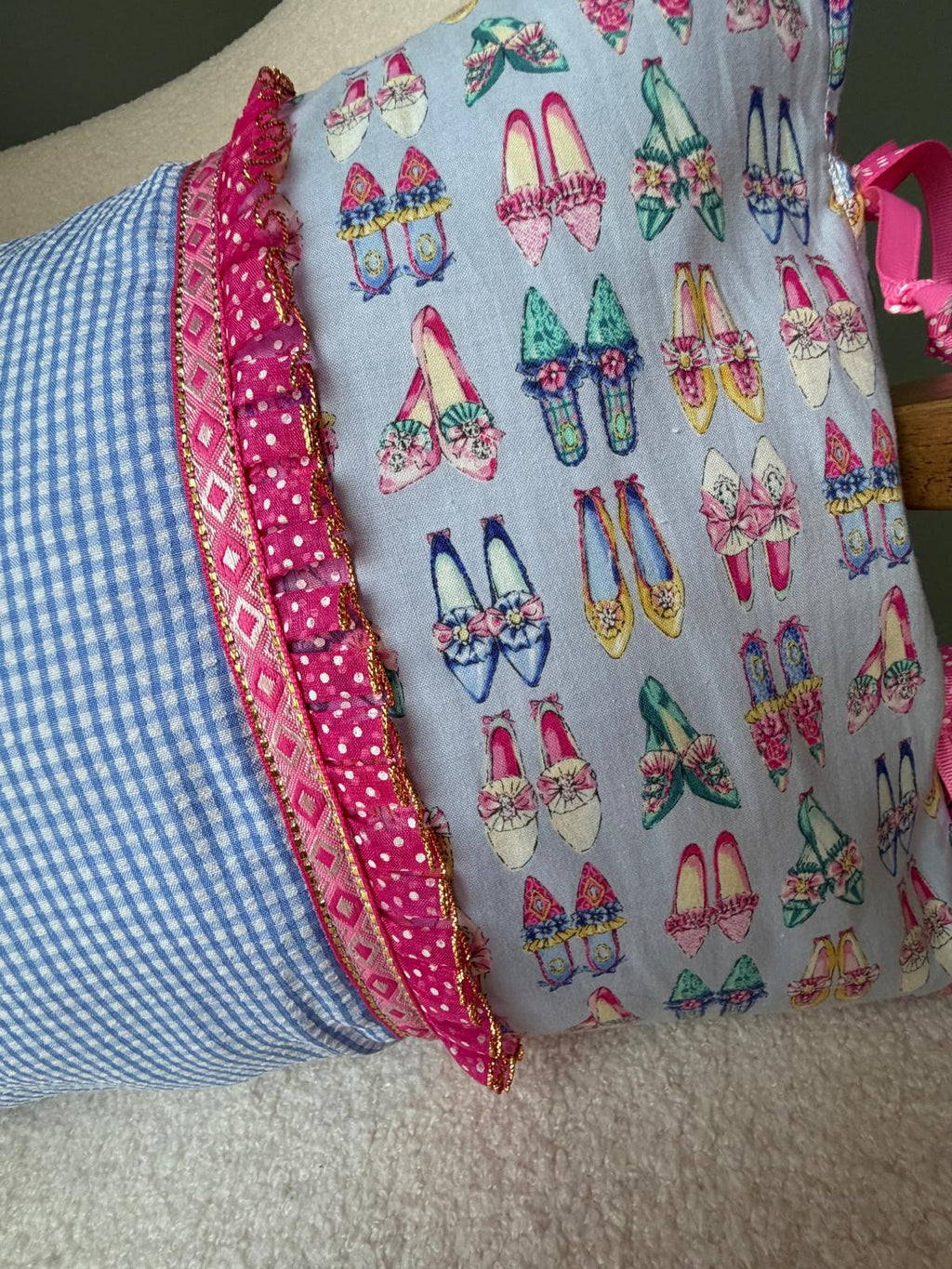 Zoom sur coussin fait main, tissu vichy bleu et impression escarpins vintage, bordure volantée rose à pois et galon doré