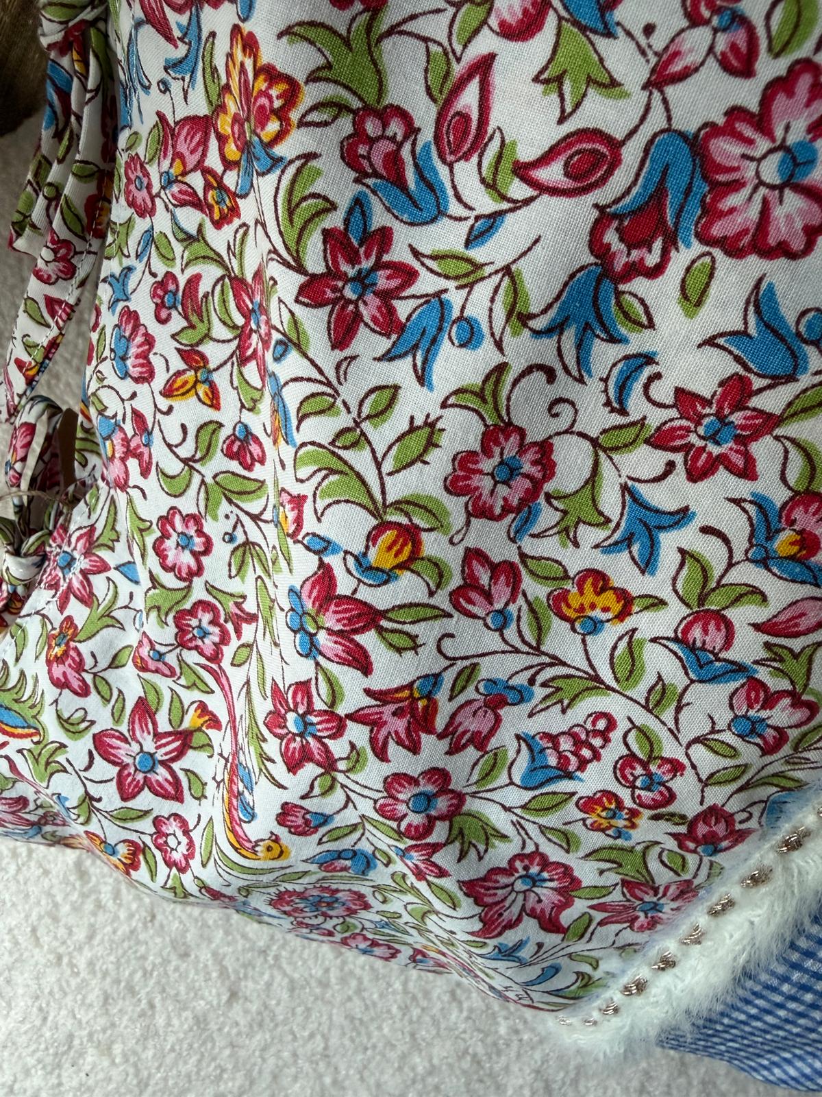 Vue rapprochée tissu liberty multicolore du coussin fait main, finitions soignées