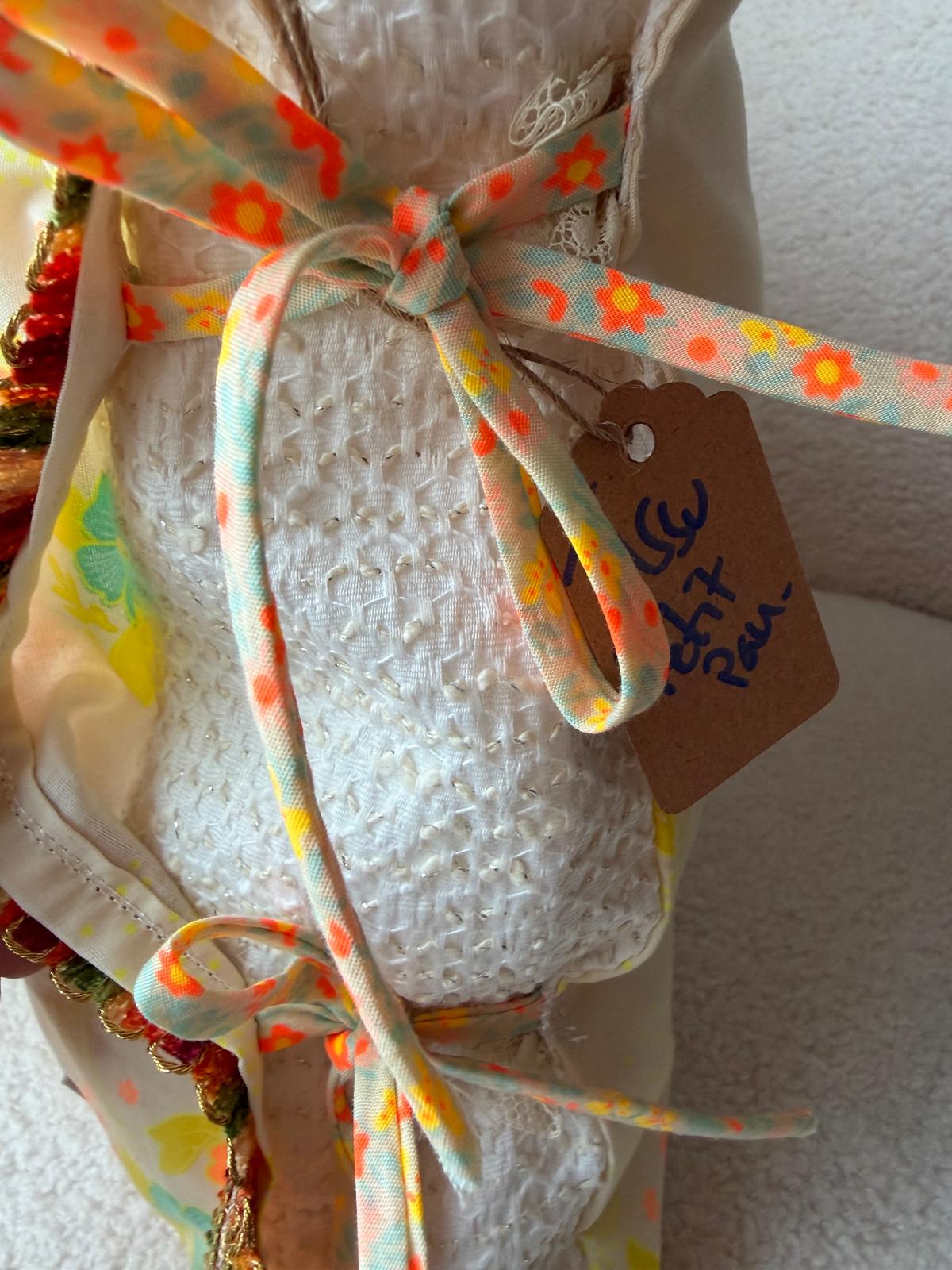 Rubans fleuris noués et étiquette au dos du coussin en coton vintage, cousu main