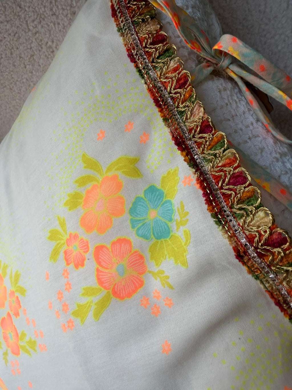 Détail du galon de velours et fil doré bordant le coussin en coton vintage fleuri, cousu main