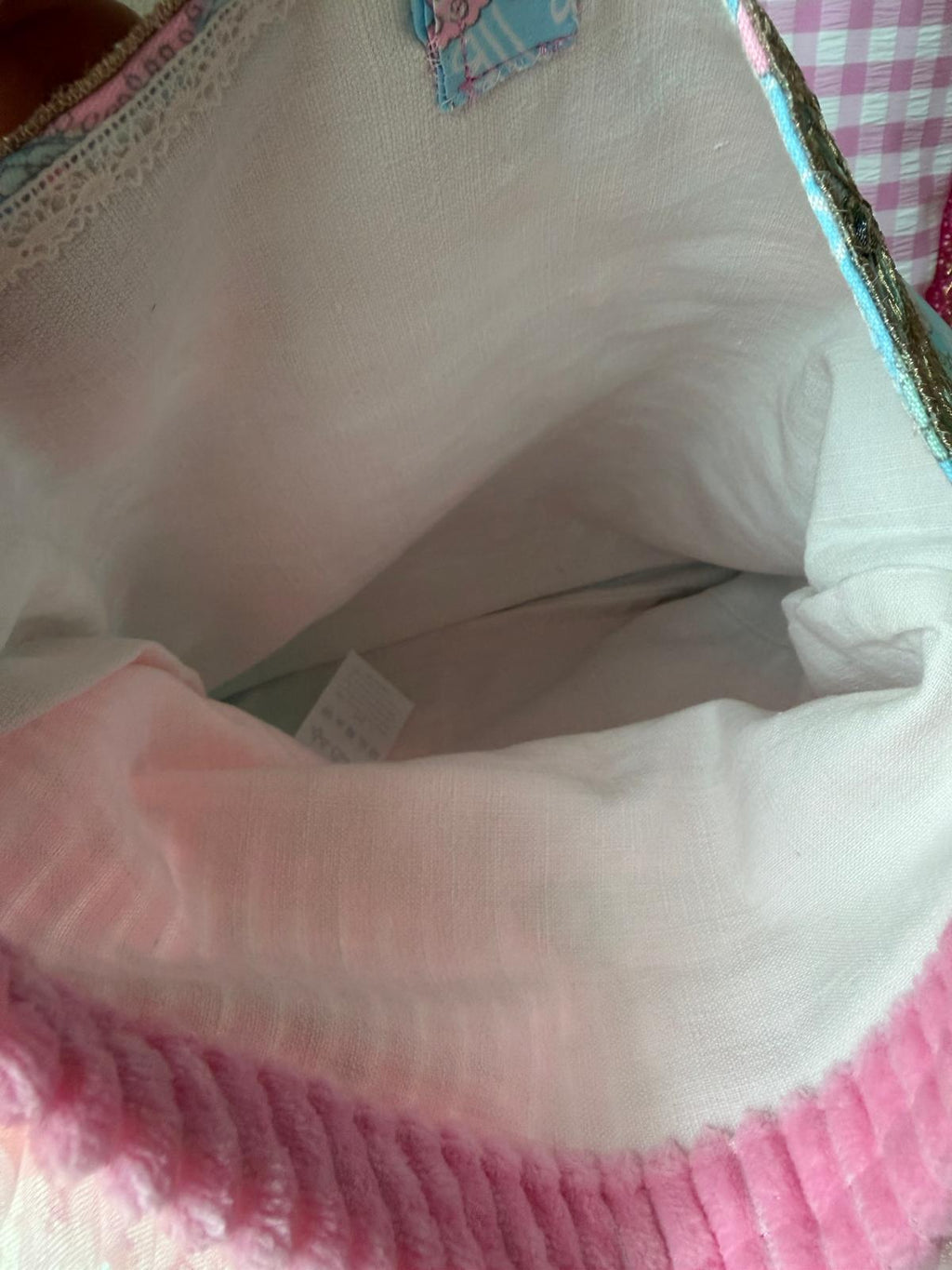 Vue intérieure de la doublure en coton blanc et de sa poche, pochette cousue main