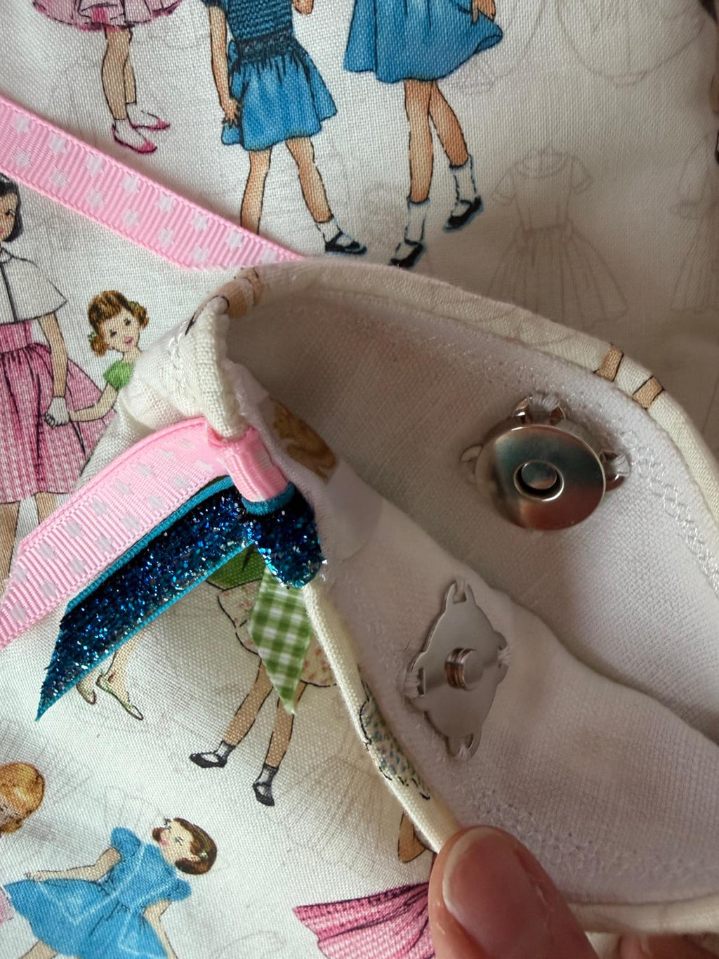 Fermeture pression pochette fait main Lyli Créarti, intérieur ivoire et tissu imprimé fillettes vintage avec rubans roses et bleus