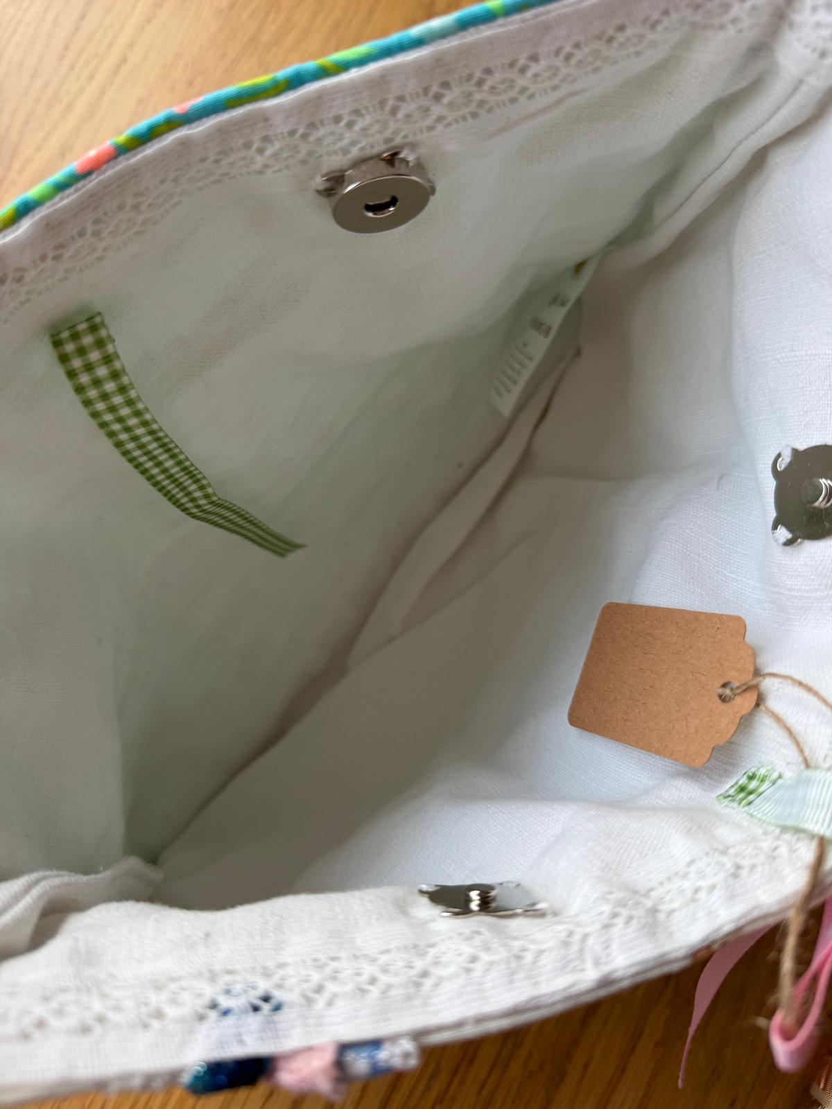 Intérieur pochette fait main Lyli Créarti, doublure blanche avec fermeture pression, étiquette artisanale et ruban vichy vert