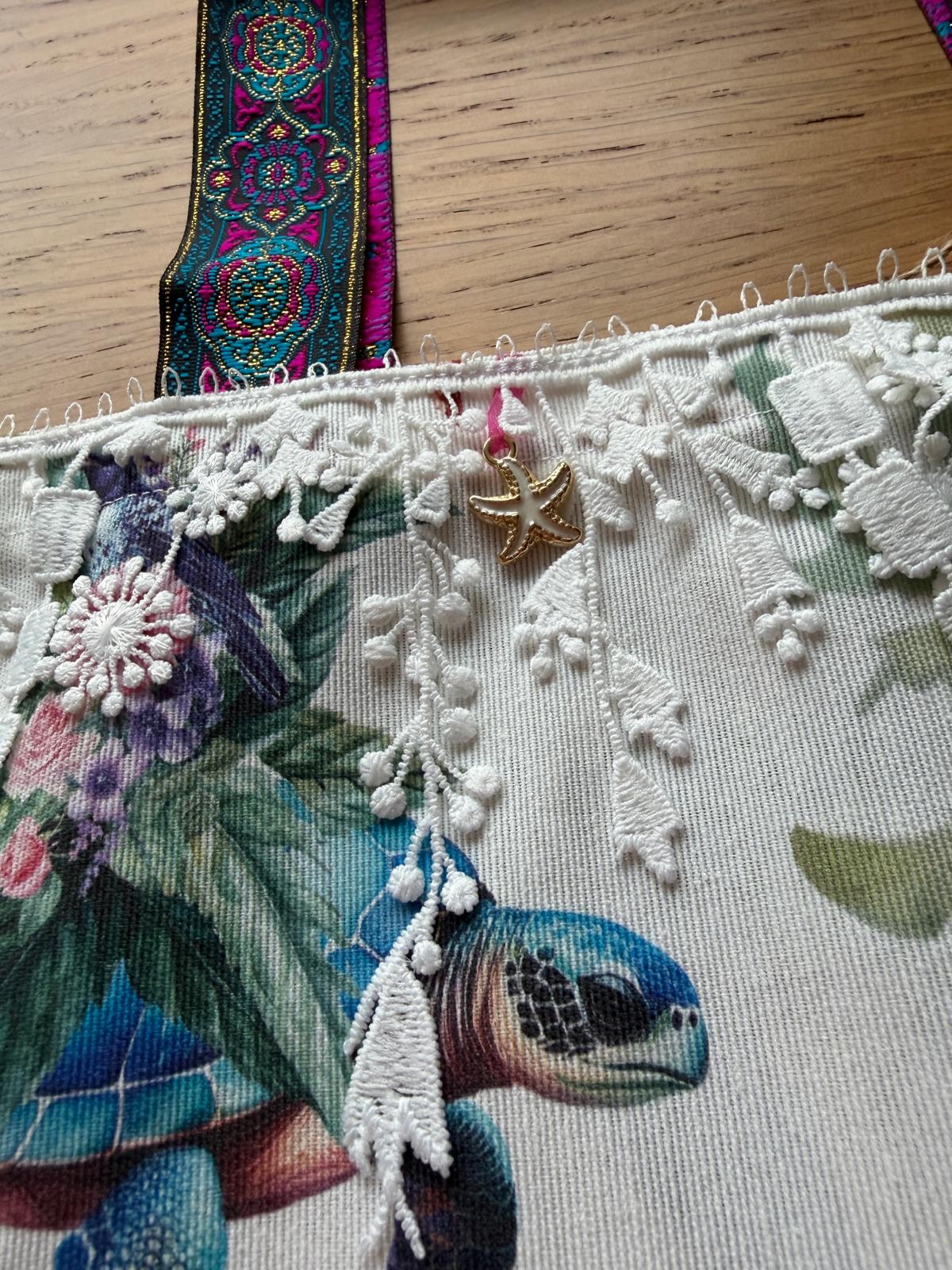 Détail dentelle blanche et breloque étoile de mer dorée sur sac cabas motif tortue, cousu main
